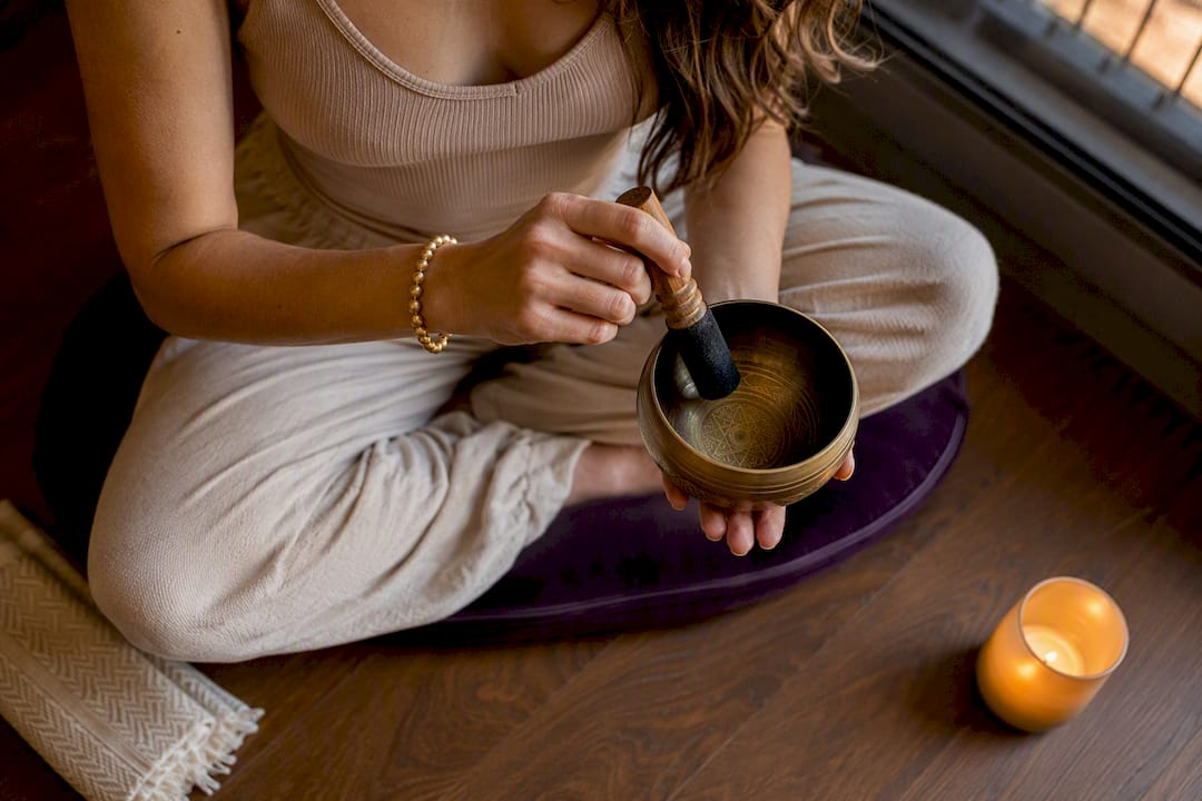 Hand striking singing bowl for breathwork