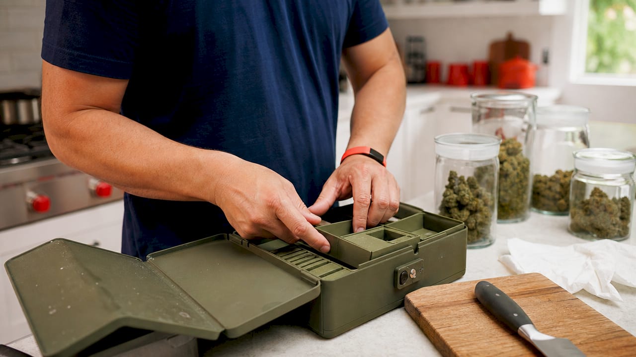 Hands rearranging modular cannabis storage compartments