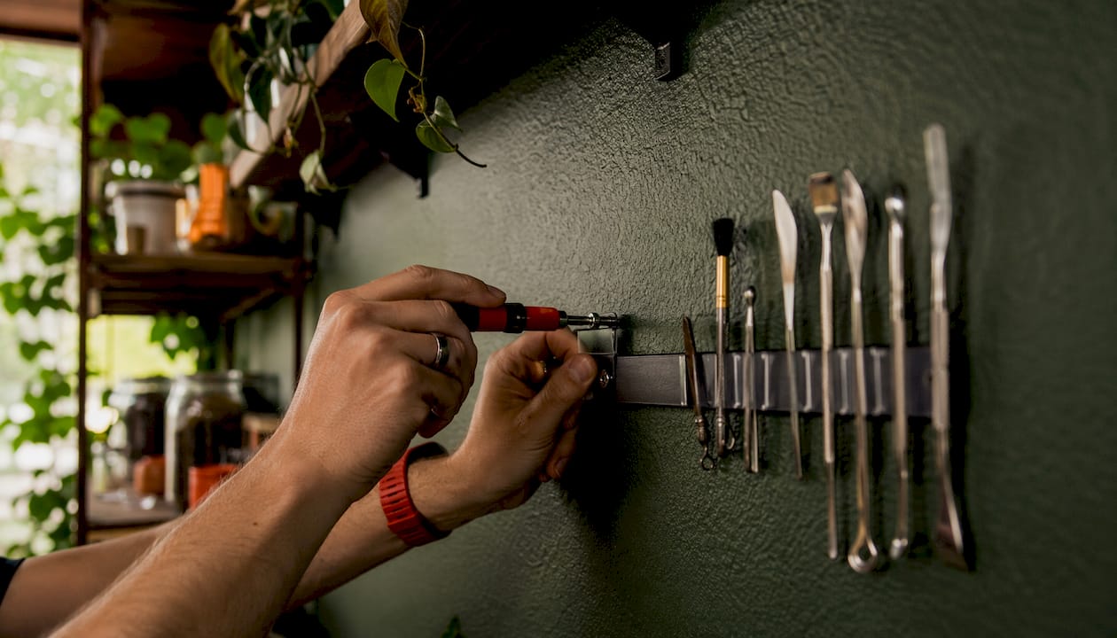 Close-up of hands installing magnetic storage strip