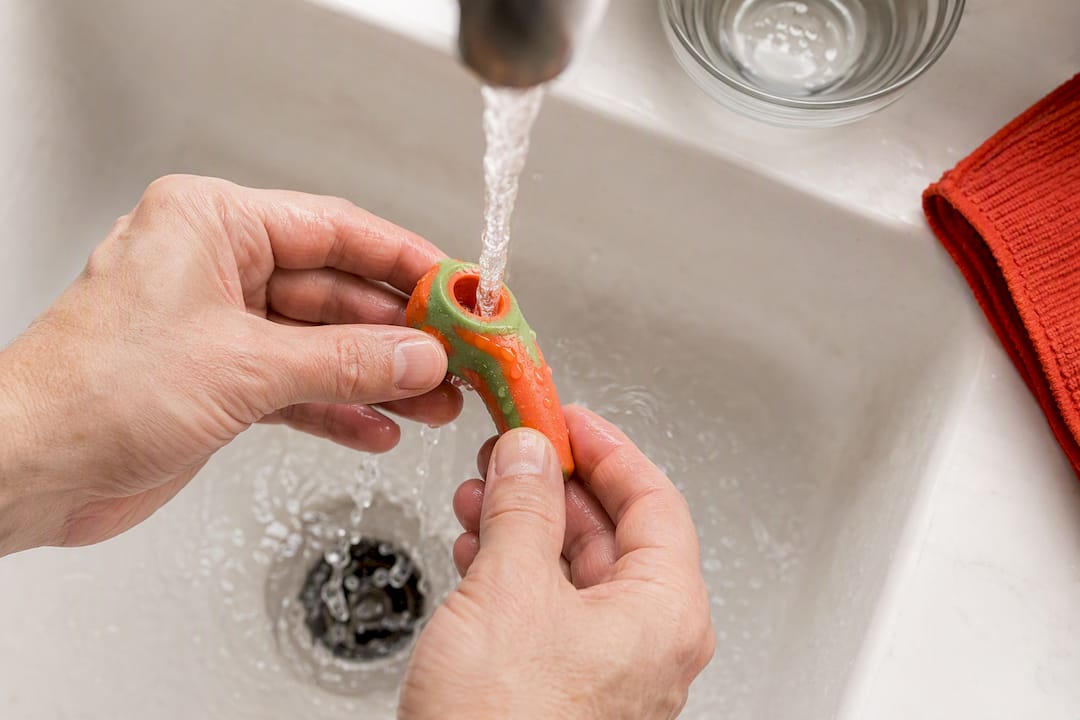 Hands rinsing a silicone pipe safely
