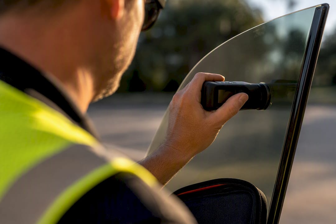 Tint meter pressed against vehicle window
