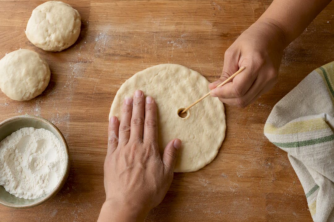 Hands shaping fry bread dough discs