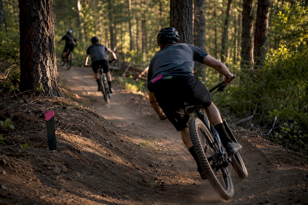 Mountain bikers riding a dry evening trail