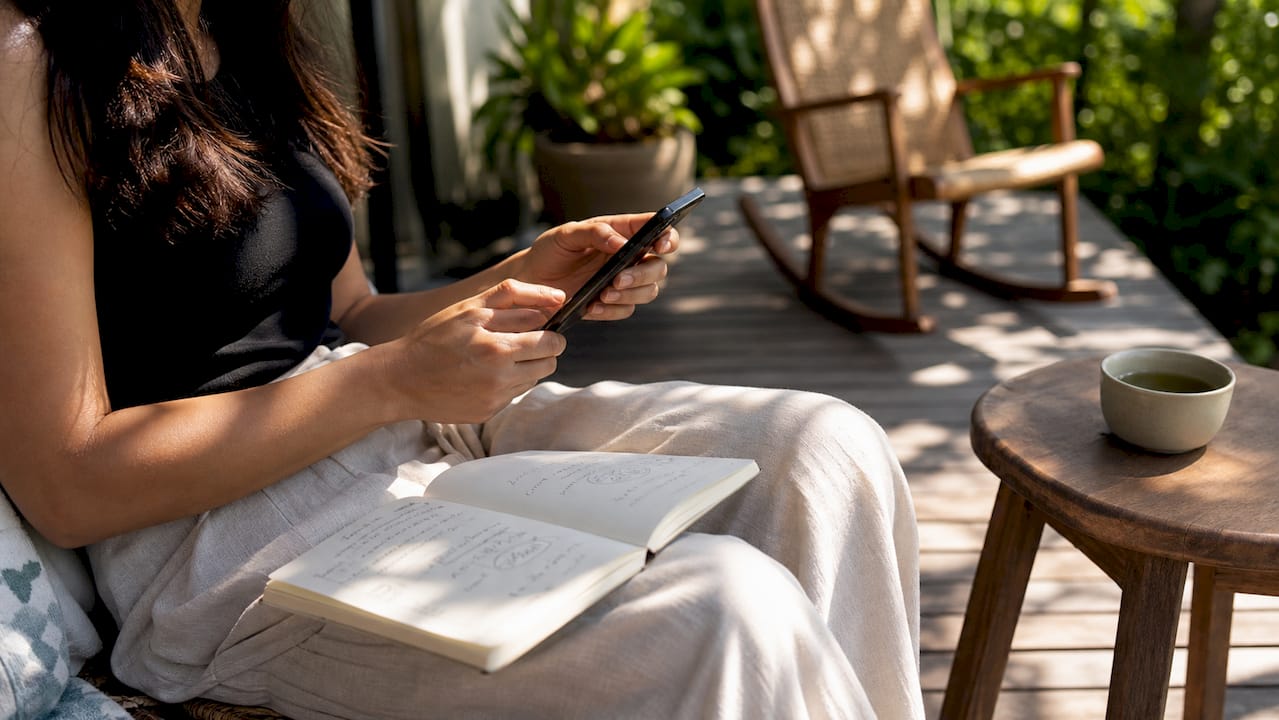 Close-up van iemand die op zijn smartphone werkt met aantekeningen voor een landingspagina.
