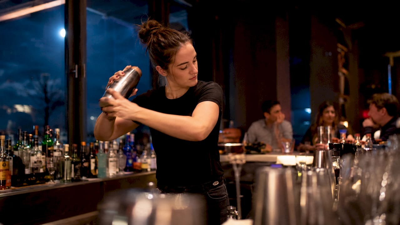 Achter de bar draait deze barman zijn hand nergens voor om: alles loopt op rolletjes.