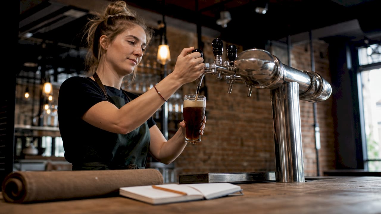 De barman tapt een glas heerlijk speciaalbier.