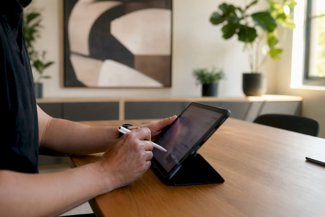 Een paar handen bladert door een lijst met webshopproducten op een tablet.