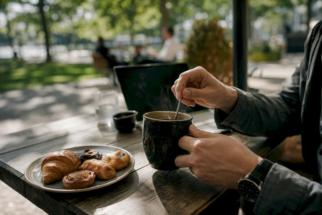 Handen die koffie inschenken op een cafétafel