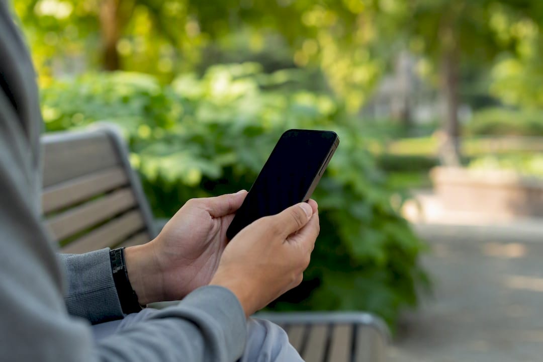 Handen die een smartphone vasthouden als symbool voor leeftijdscontrole