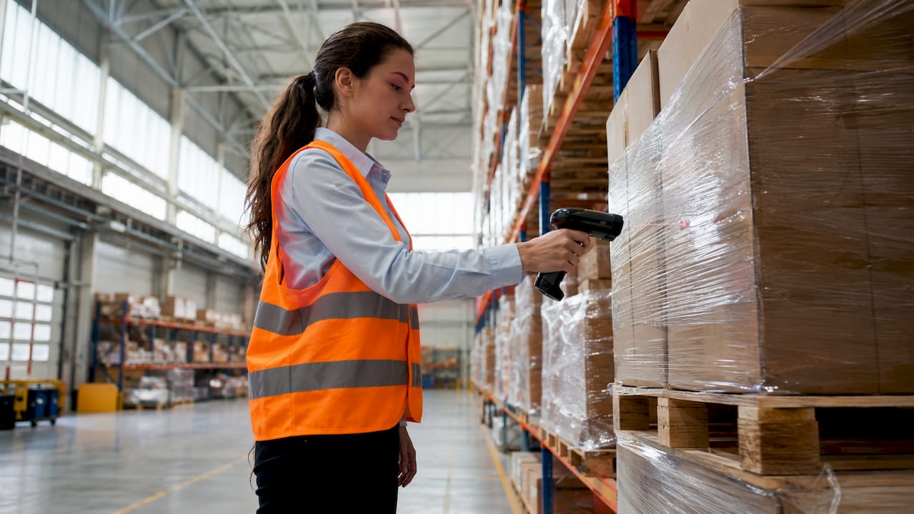 Magazijnmedewerker die pallets scant tijdens het verwerken van bestellingen