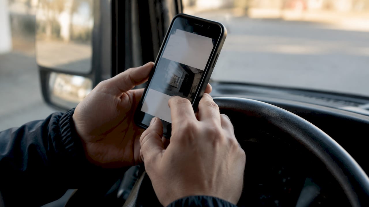Detailopname van handen die een chauffeursapp bedienen