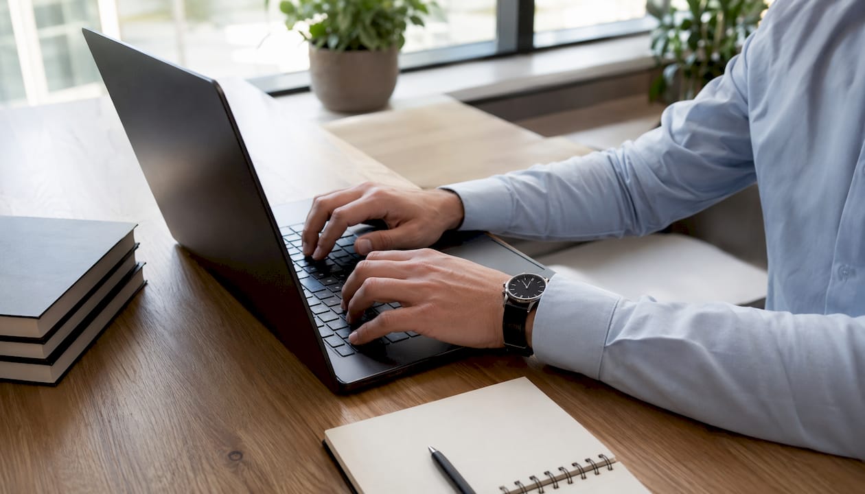 Iemand typt op een laptop tijdens een logistiek overleg in de vergaderruimte.