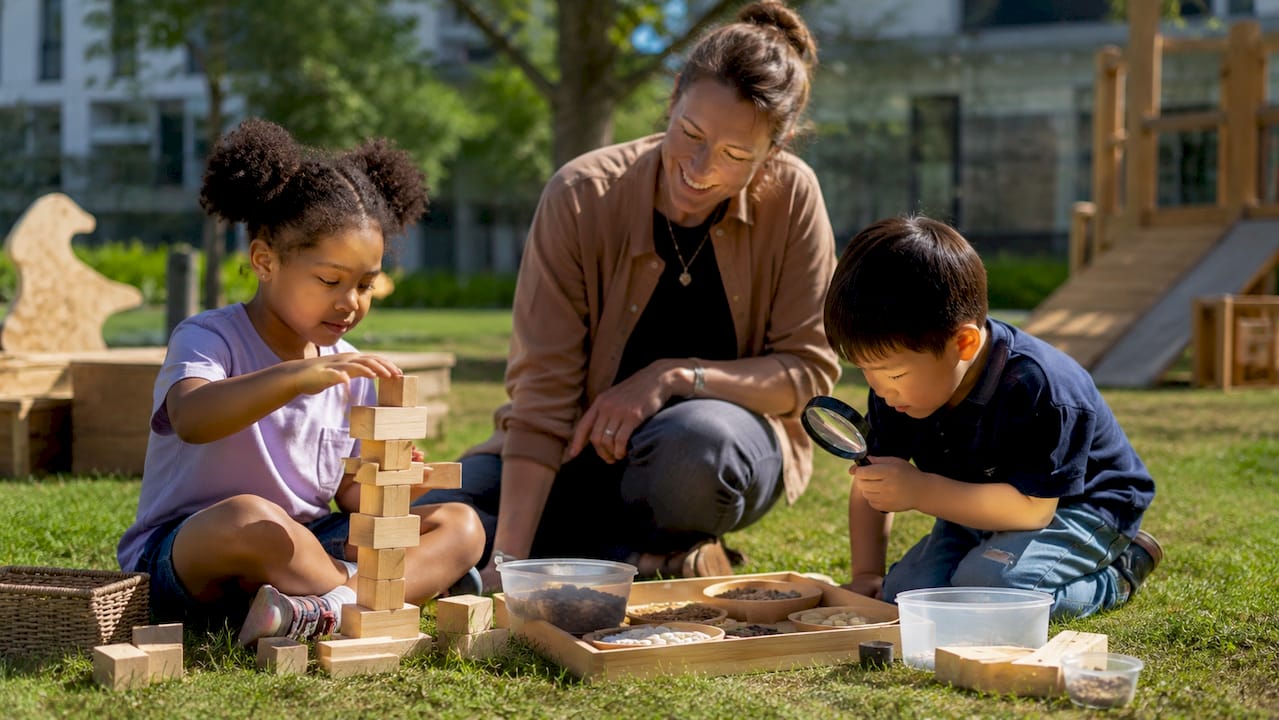 Preschool children investigating STEM outdoors with teacher