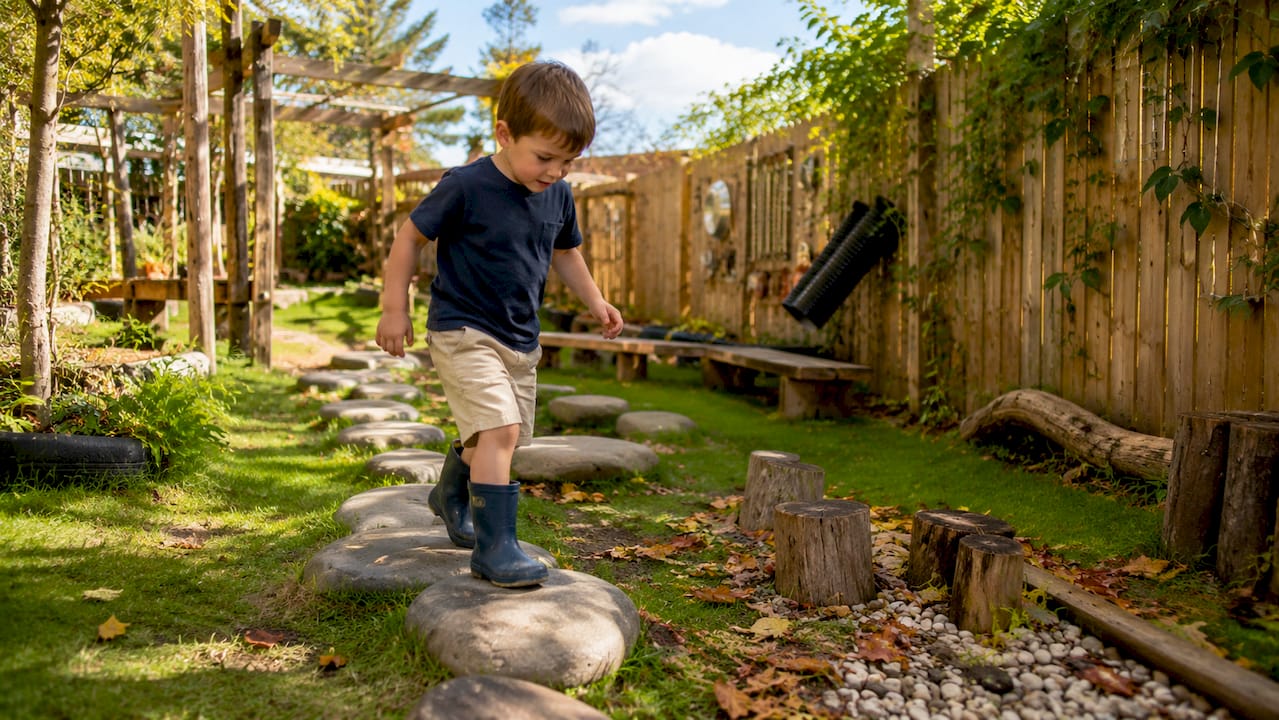 Preschooler balancing on outdoor play log