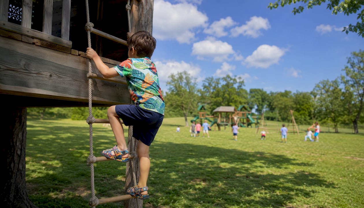 Child climbing playground structure outdoors