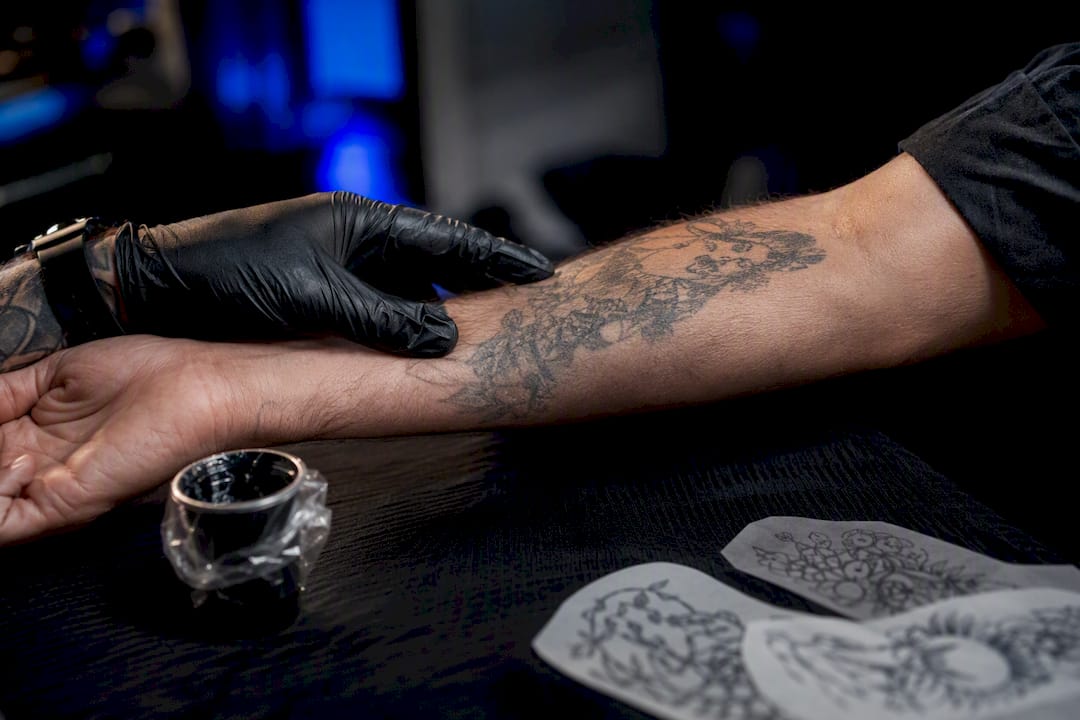 Artist assessing an existing tattoo for cover-up