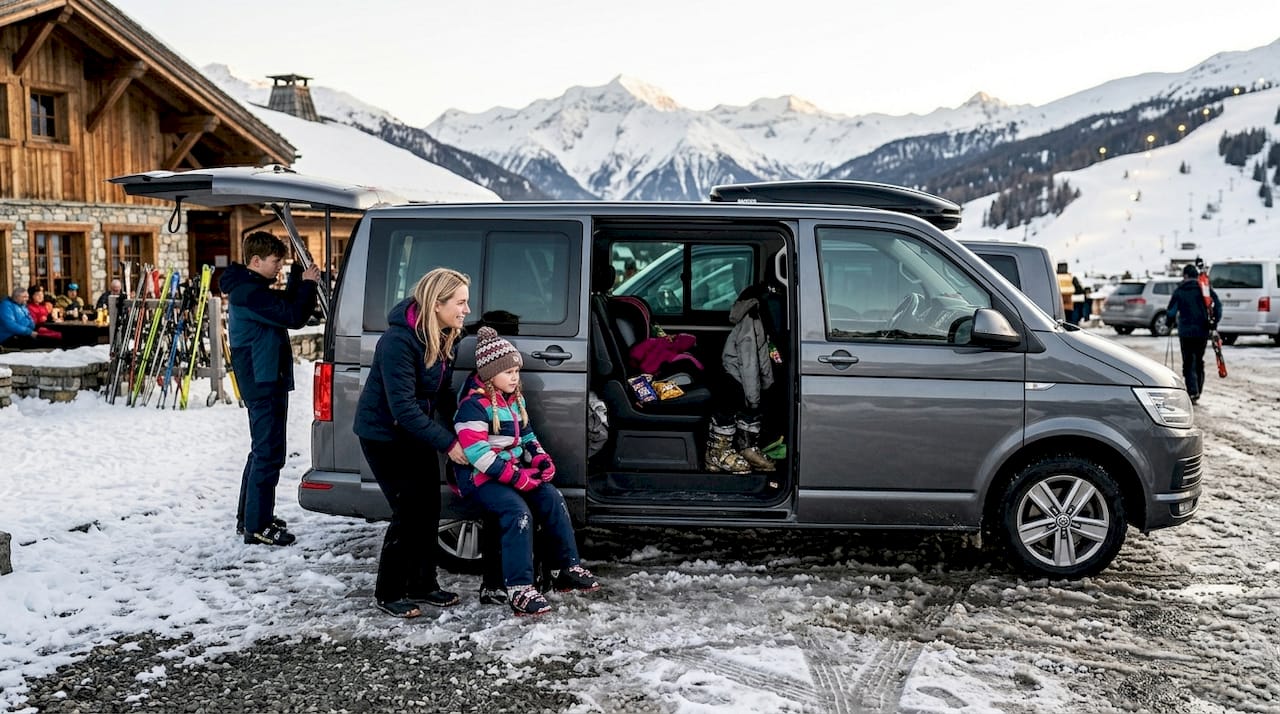 Family loading ski gear into shuttle van