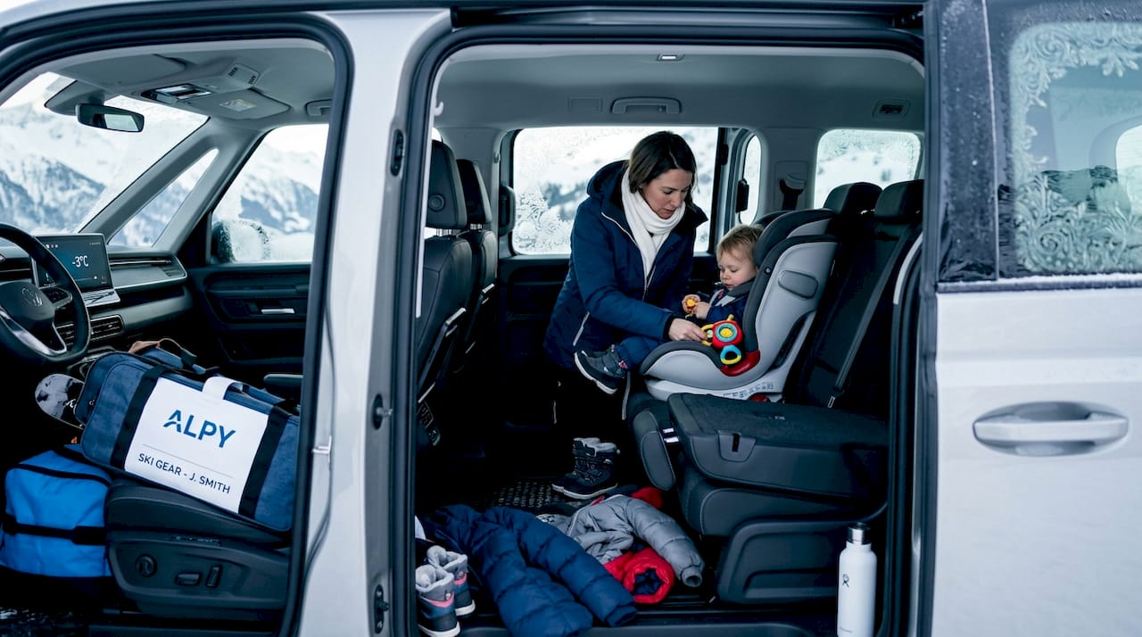 Mother arranging child seat in minivan