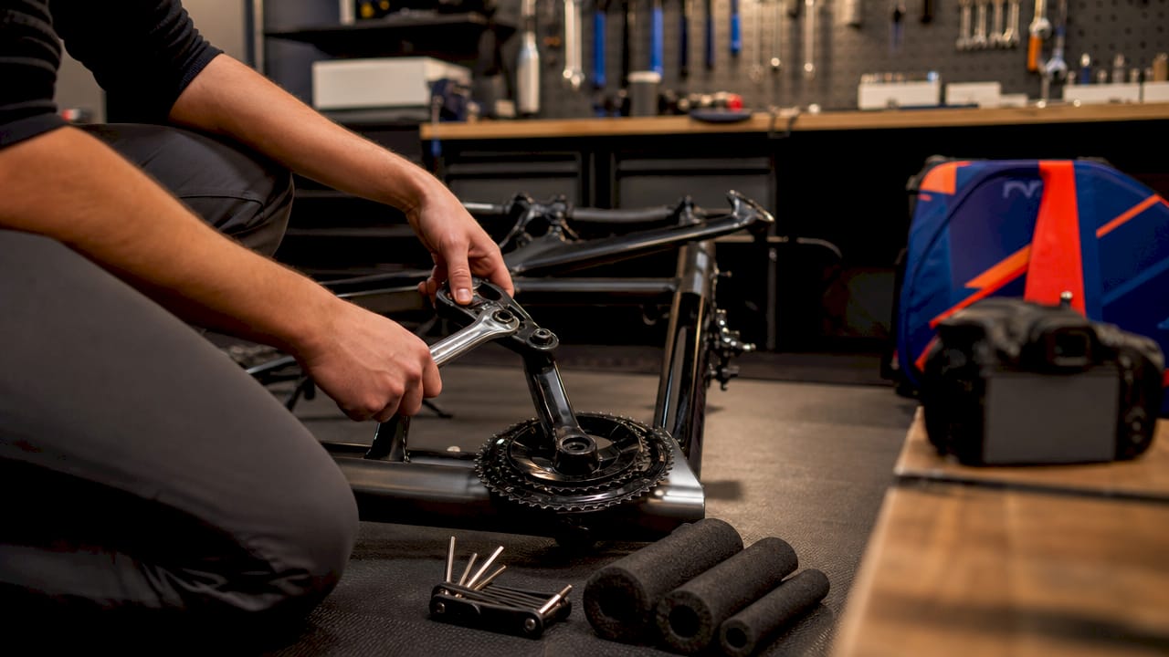 Hands disassembling road bike parts carefully indoors