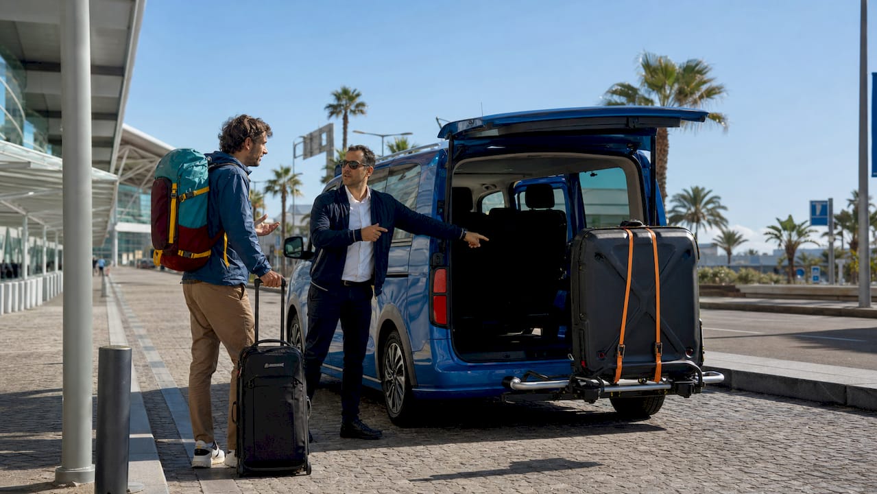 Traveler and driver by car with bike cases outside airport