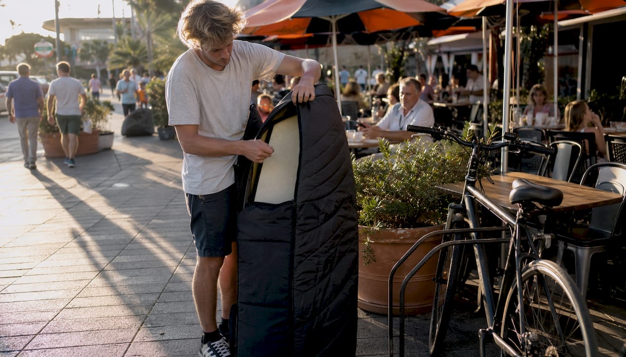 Surfer unloading surfboard at Nice Airport luggage claim