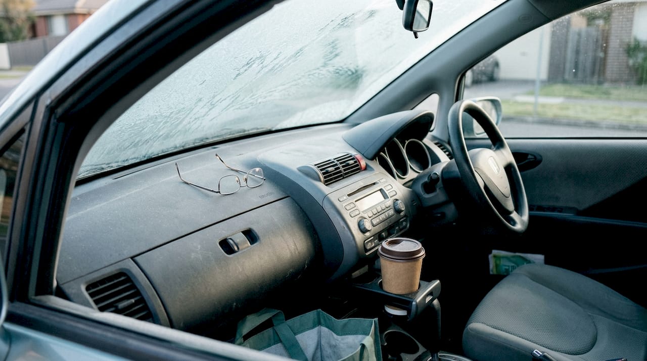 Glasses left on car dashboard with frost