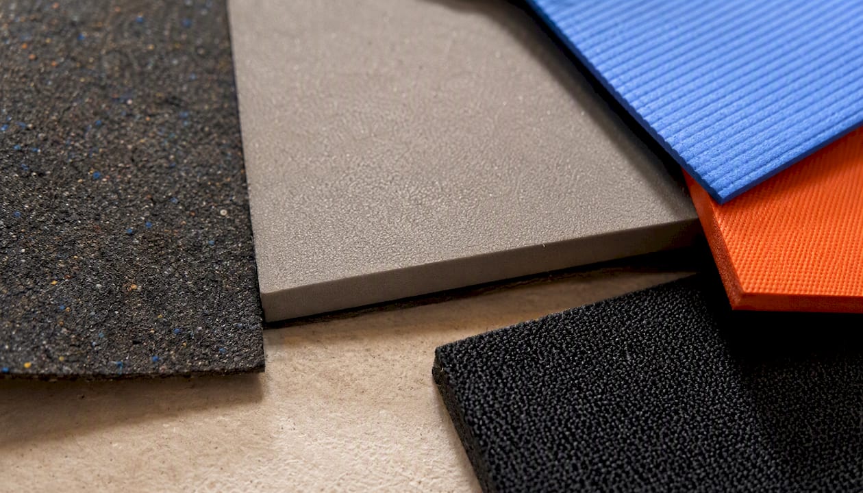 Detailaufnahmen verschiedener Fitnessmatten zeigen die unterschiedlichen Oberflächenstrukturen und Materialien.