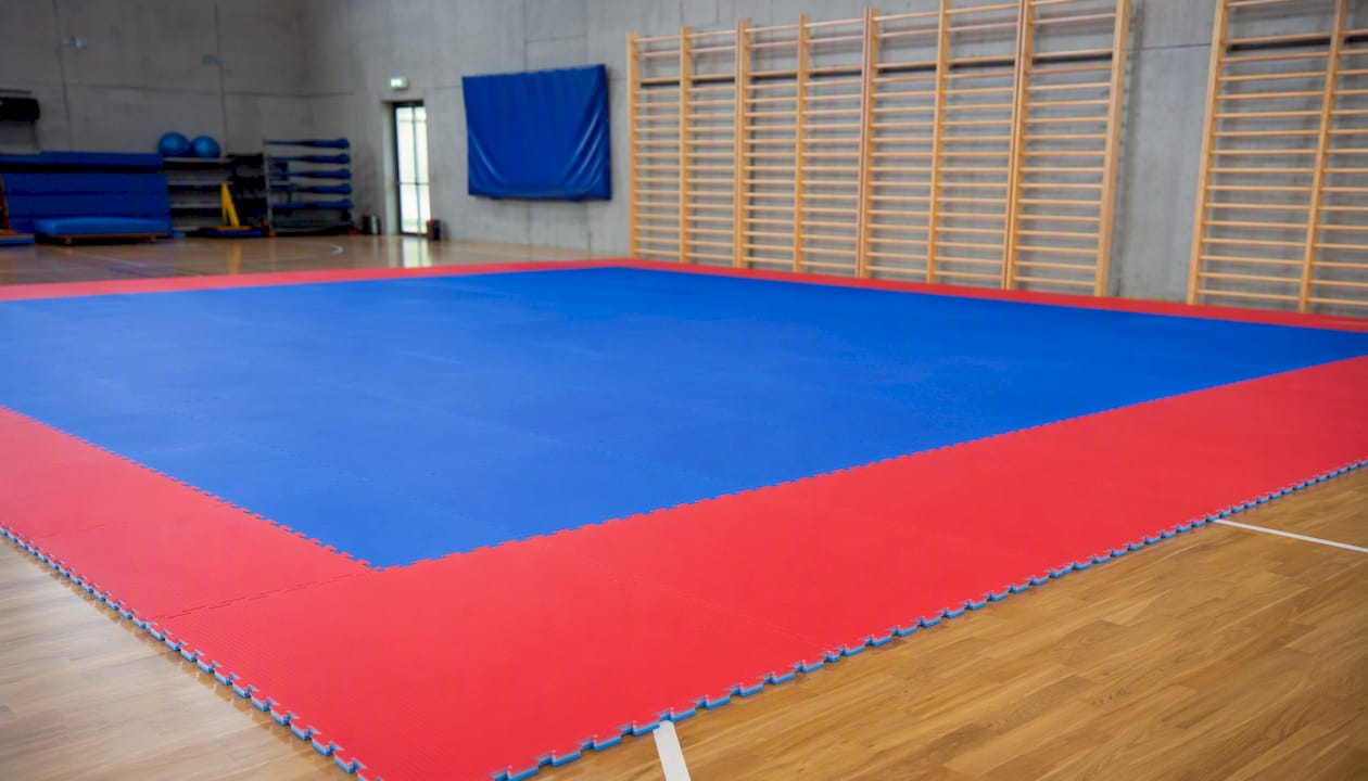 Detailansicht einer Kampfsportmatte mit markanter roter Sicherheitszone