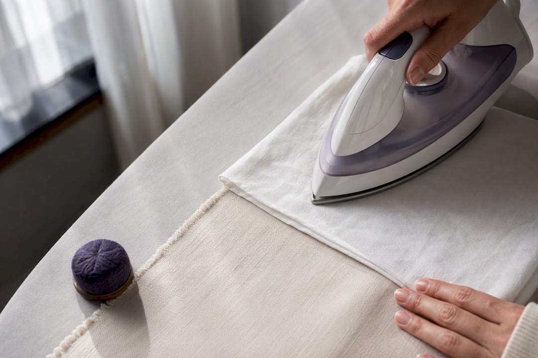 Bügeleisen mit Baumwolltuch auf empfindlichem Material