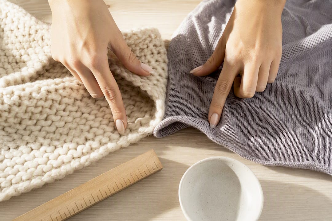 Zwei Strickmuster werden von Händen verglichen