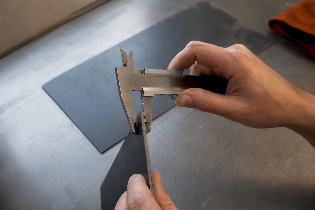 Mit dem Messschieber wird die Dicke eines Metallblechs gemessen