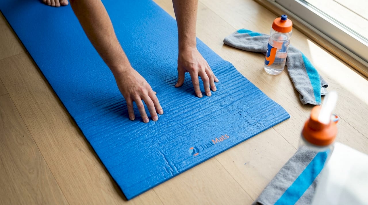 Mit den Händen wird überprüft, wie rutschfest die Oberfläche der Yogamatte ist.