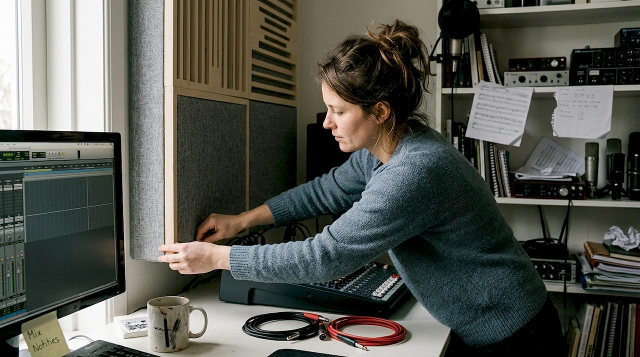 Absorptie in studio: essentiële gids voor betere geluidskwaliteit 2 Een vrouw stelt een geluidsabsorberend paneel af in de studio.