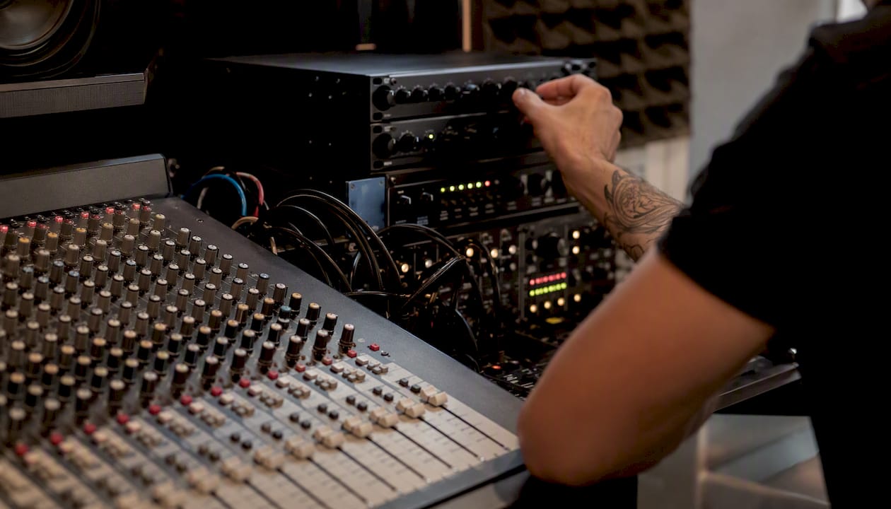 Hardware synth opnemen: de complete workflow voor jouw studio 2 Handen die hardware-effecten instellen op een mengpaneel
