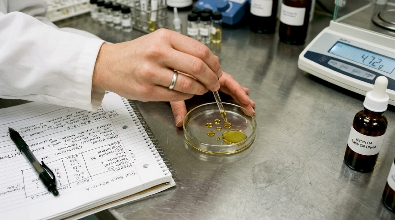 Lab technician handling cosmetic oil samples