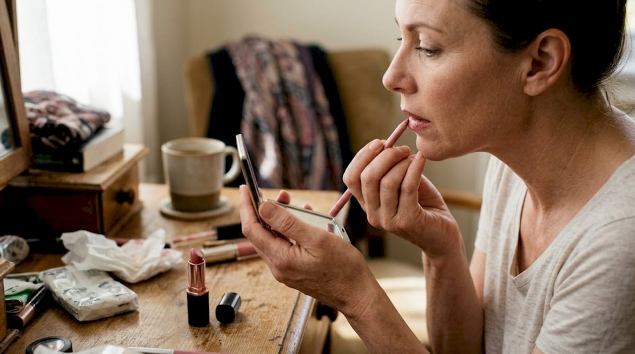 Close-up woman over 40 using lip liner