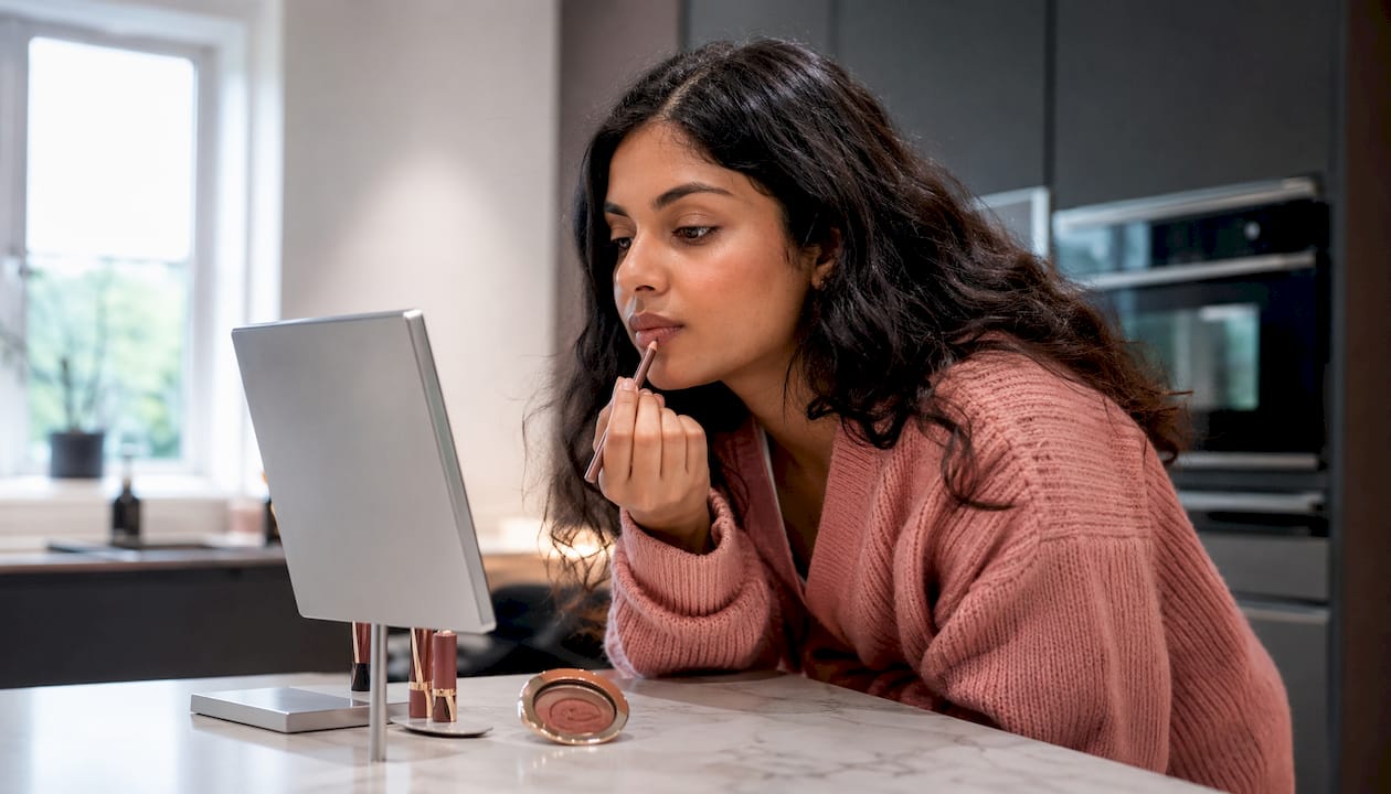 Woman applying nude lip liner at vanity
