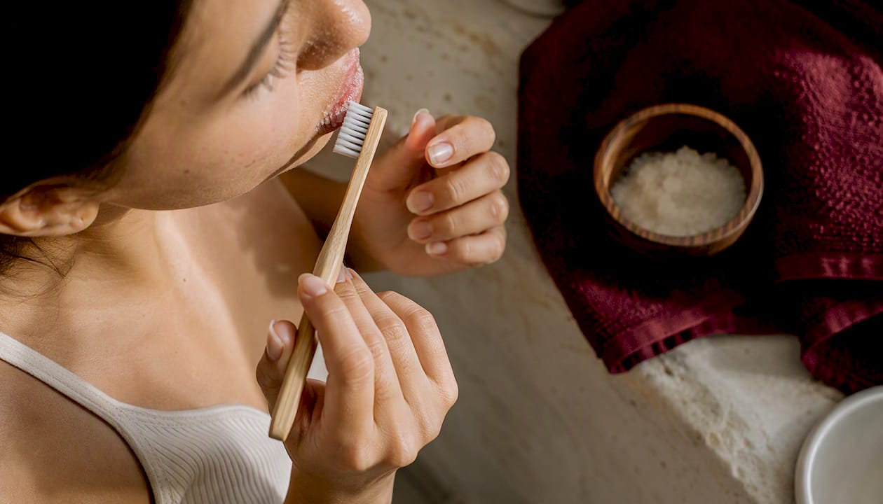 Hands exfoliating lips with toothbrush close-up