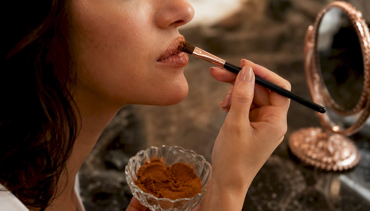 Applying cinnamon lip plumper on lips