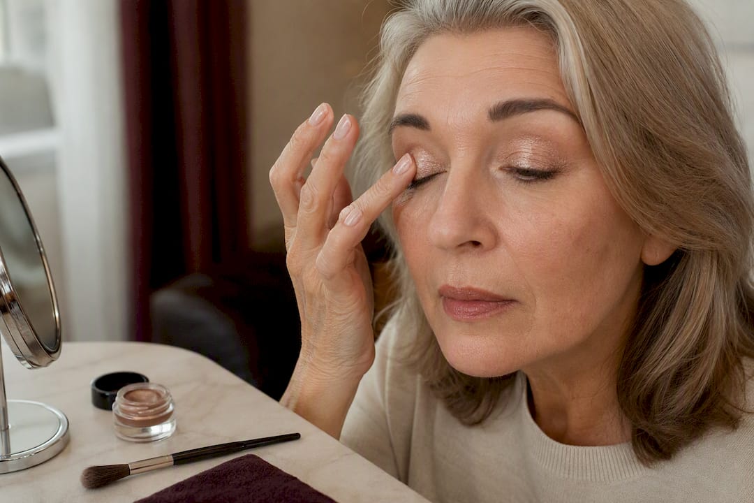Cream eyeshadow application on mature eyelid