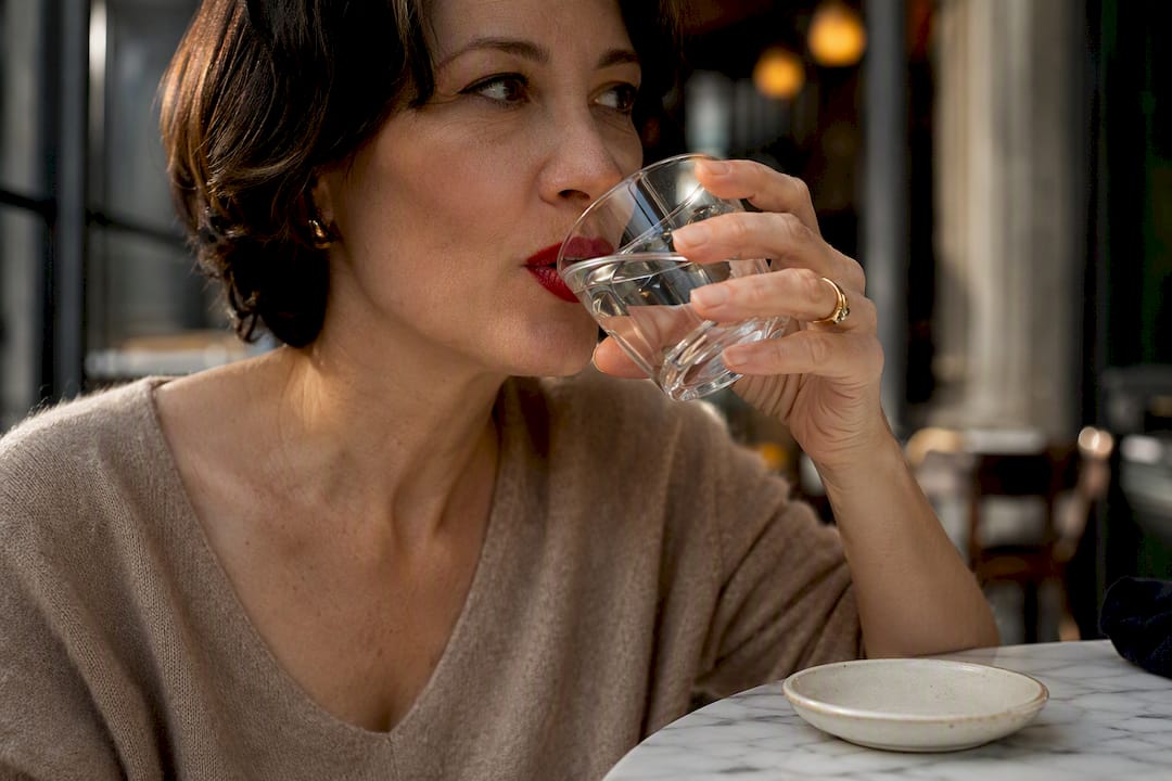 Woman checking red lipstick after drinking