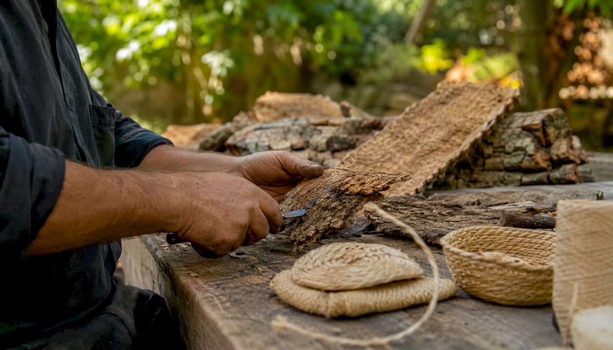 Craftsman shaping cork bark by hand
