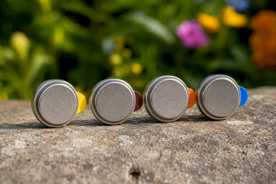 Four hearing aid batteries with color-coded tabs