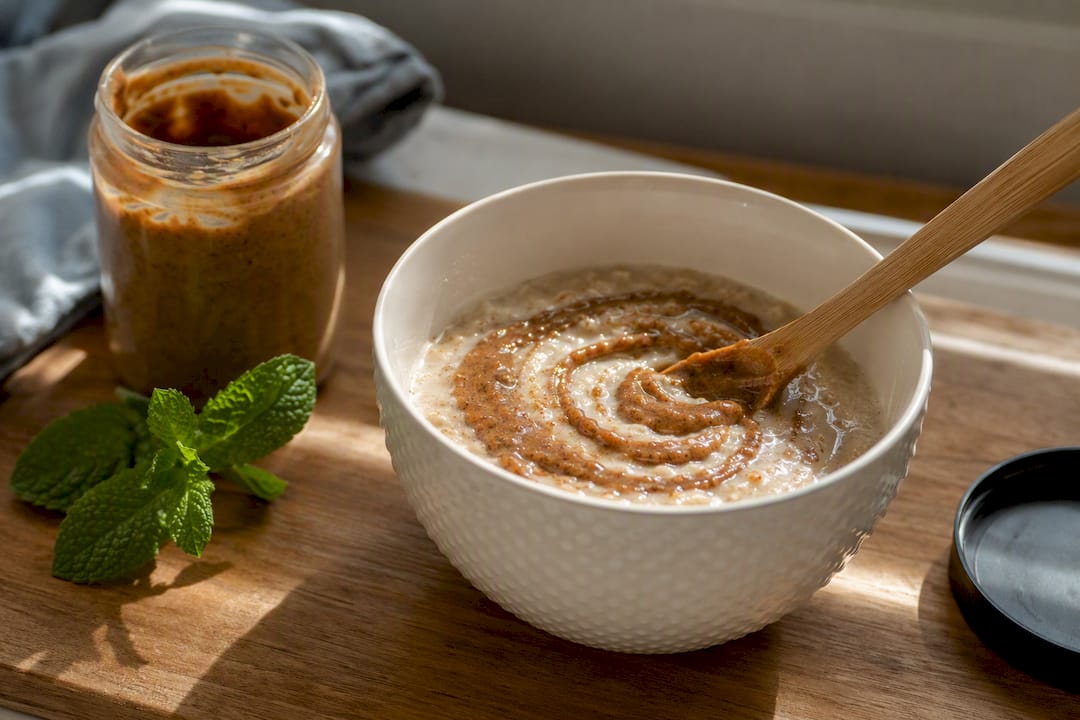 Pecan nut butter stirred into porridge bowl