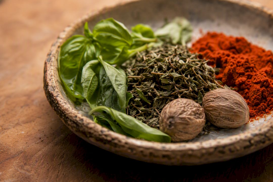 Bowls of fresh herbs and ground spices