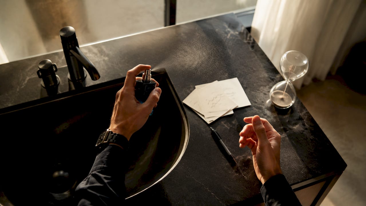 Detalle de la aplicación de perfume sobre la piel de un hombre