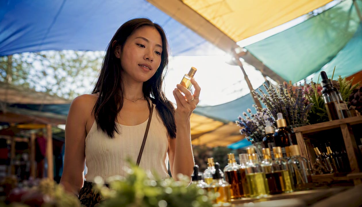 Una mujer explora los aromas en una boutique de perfumes artesanales.