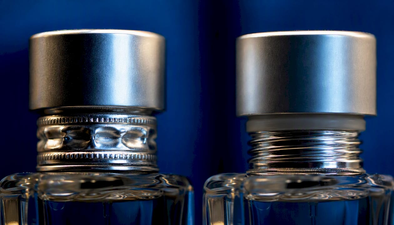 Close-up of crimp-neck and screw-neck perfume bottle tops