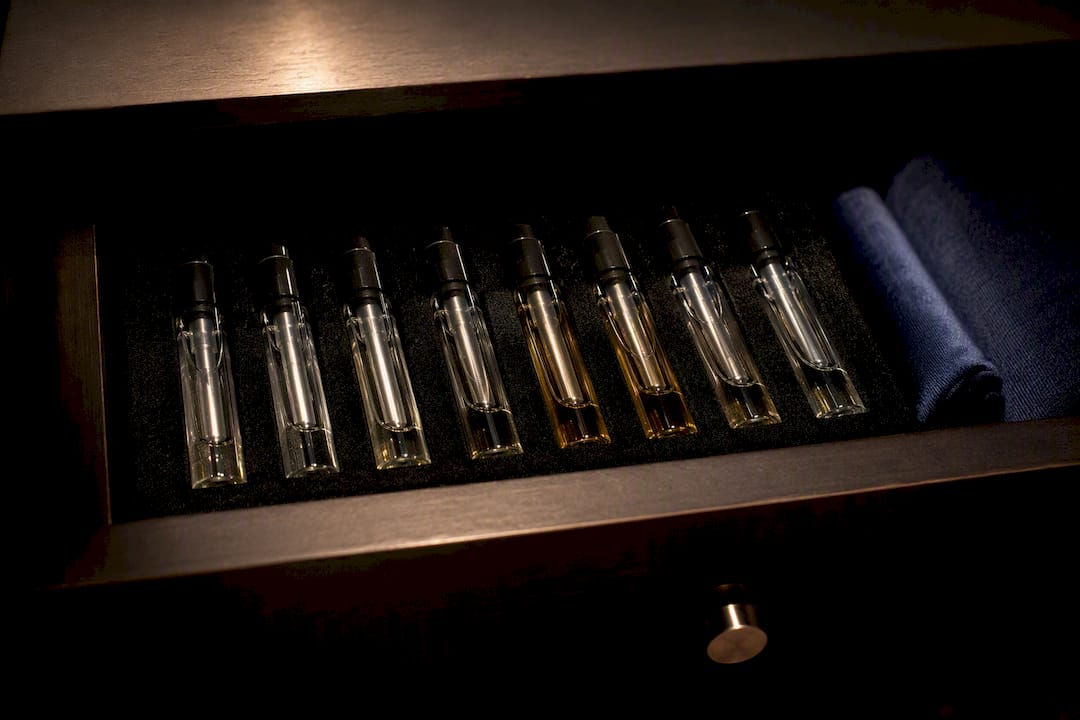 Frascos de perfume almacenados en posición vertical en un cajón oscuro