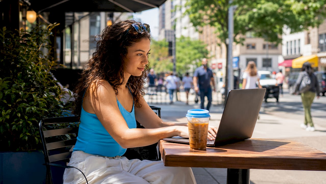 Woman using laptop to compare hotel rates in café